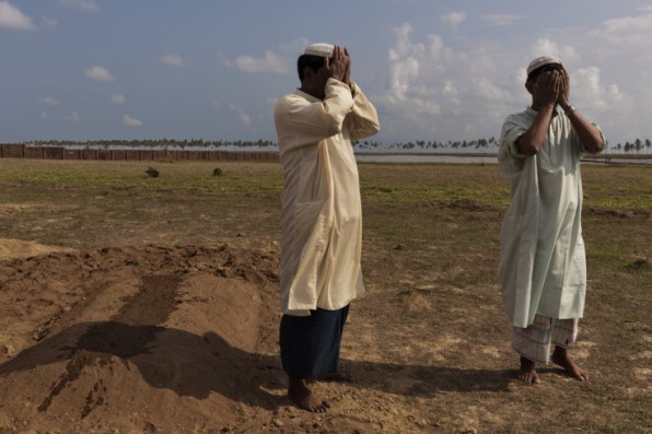 "Two men are seen mourning at the funeral of a woman who died from stomach disease." Photo by James Nachtwey for Time
