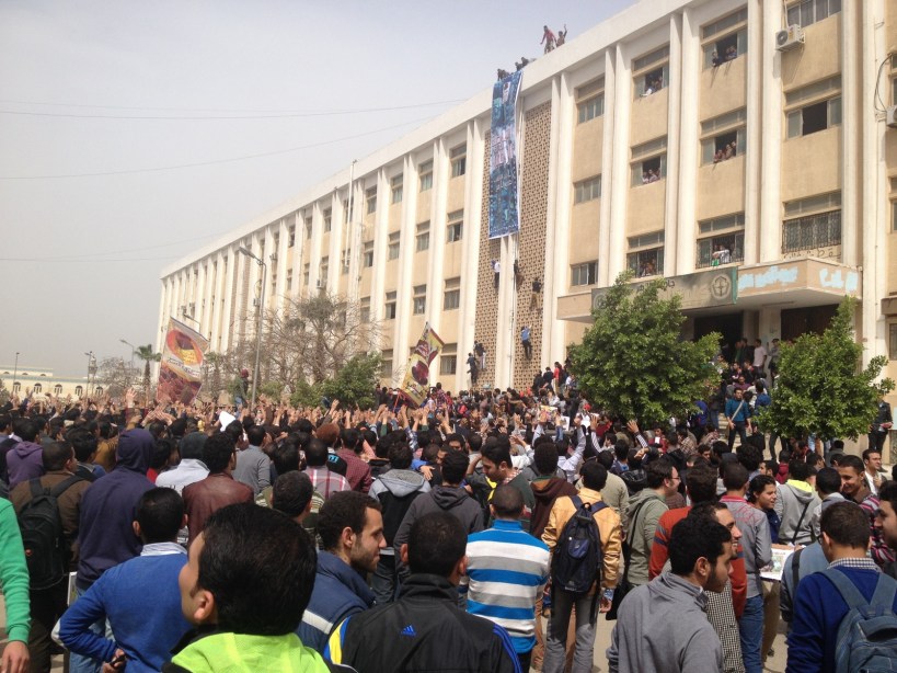 Students sit outside a campus building at Al-Azhar University in Cairo in March, 2014.